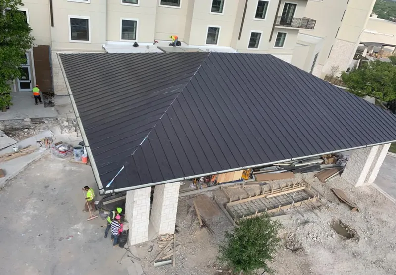 Metal roofing installation team working on a commercial building in Cascades